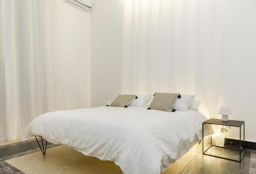 カターニアにあるB&B 4 ELEMENTI CATANIAのベッドルーム1室(白いシーツ付きのベッド1台、窓付)