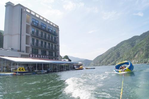 a boat in the water in front of a building at Gapyeong Dolgorae Resort in Gapyeong
