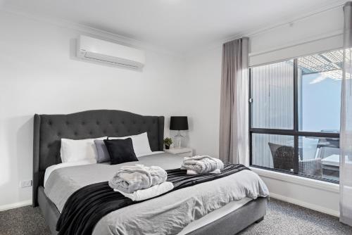 a bedroom with a bed with a large window at Marine Cove in Yarrawonga