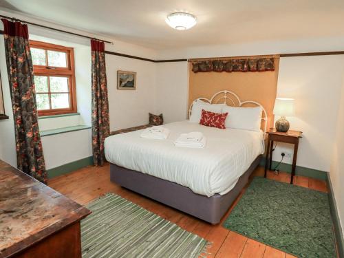 a bedroom with a large bed and a window at Rose Cottage Coniston in Coniston