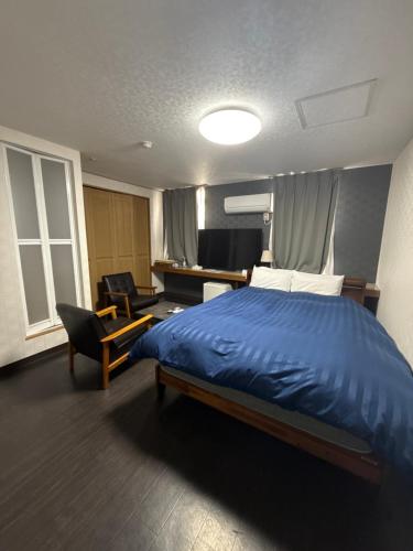 a bedroom with a large blue bed and a desk at 水戸第一ホテル本館 in Mito