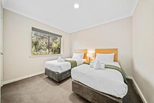 a bedroom with two beds and a window at Fairway Retreat in The Vines