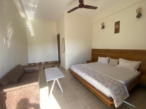 a bedroom with a large bed and a couch at Sanskriti in Kotdwāra
