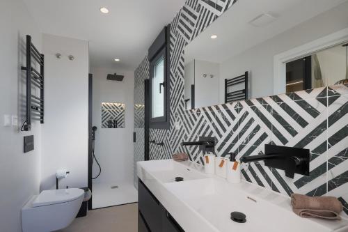 a bathroom with a black and white patterned wall at Villa Don Grosa - Luxury Family Retreat in Torre-Pacheco