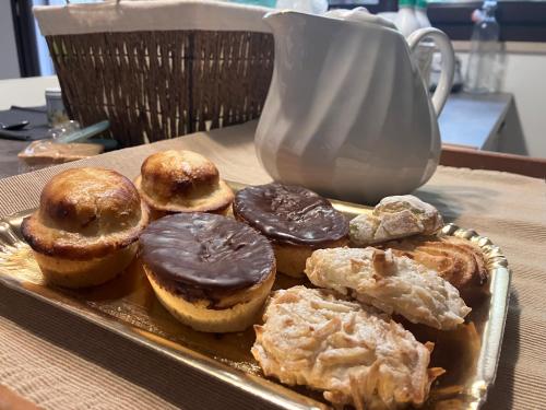 a tray of pastries on a table with a tea pot at AGAVE Suite in Lecce