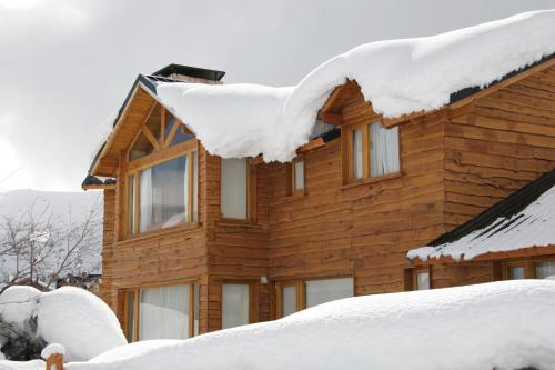a wooden house covered in snow at Galileo Boutique Hotel in San Carlos de Bariloche