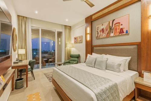 a bedroom with a bed and a living room at Amaari Beach Resort in Kanyakumari