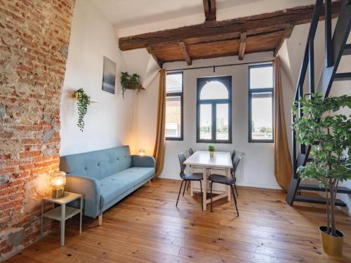 a living room with a blue couch and a table at Two-bedroom apartment by the river in Antwerp