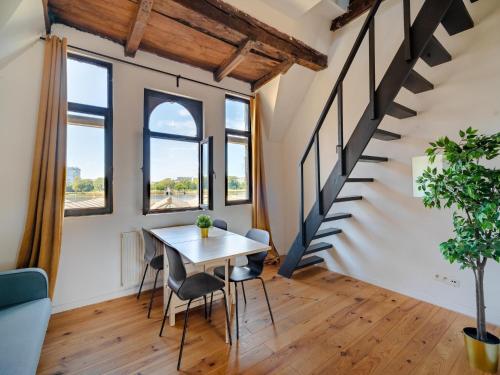 a room with a table and chairs and a staircase at Two-bedroom apartment by the river in Antwerp