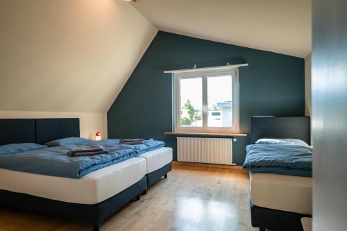 a bedroom with two beds and a window at Steinbockblick Maienfeld in Maienfeld