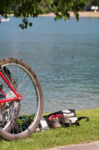 a bike parked on the grass next to a body of water at Energy Hotel in Calceranica al Lago