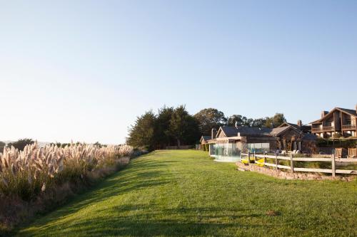 a field of grass with houses in the background at The Lodge at Bodega Bay in Bodega Bay
