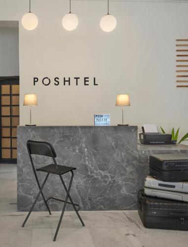 a black chair sitting in front of a reception desk at Poshtel VNS in Varanasi