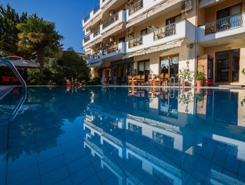 una piscina di hotel di fronte a un edificio di Syrtaki Hotel a Ofrínion