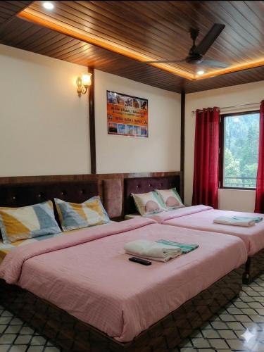 two beds in a bedroom with red curtains at Trinetra Himalayan Stay in Phata