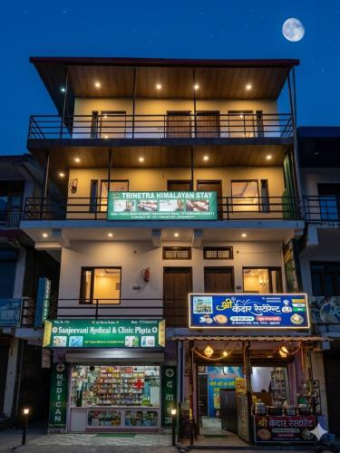 a building with signs in front of a store at Trinetra Himalayan Stay in Phata