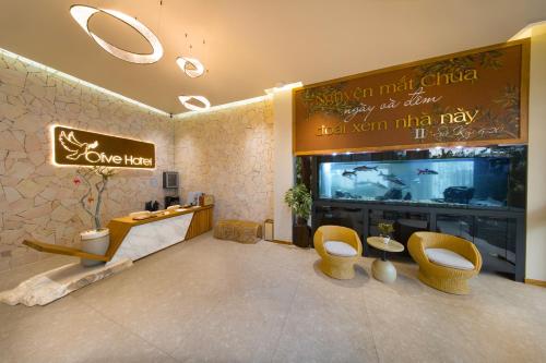 a living room with two chairs and a television at Olive Hotel Da Lat in Da Lat