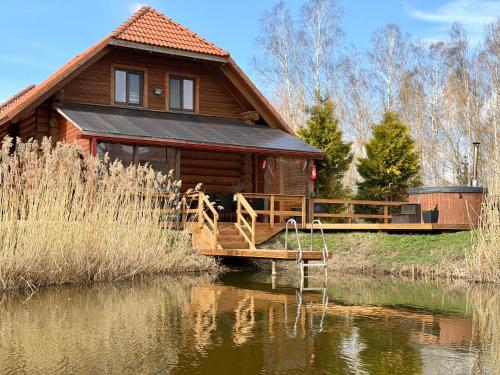 a log cabin with a dock in the water at Kundziņu salas in Vidriži