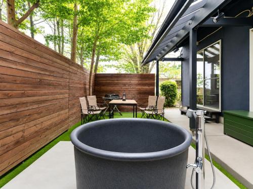 a bath tub on a patio with a table and chairs at rinne 伊豆 Private Spa in Ito
