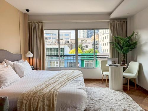 a bedroom with a bed and a large window at Common Living Iconsiam in Bangkok