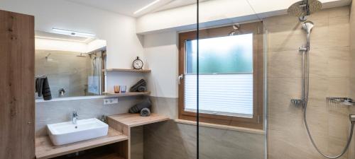 a bathroom with a sink and a shower at Apartments Sayonara in Castelrotto