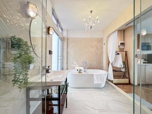 a bathroom with a large tub and a sink at Common Living Iconsiam in Bangkok