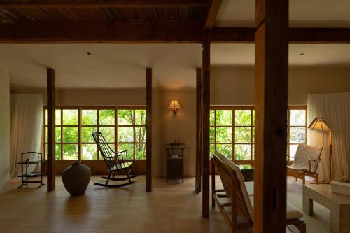 a living room with rocking chairs and windows at 蜜圡 Mitzdo in Tamano