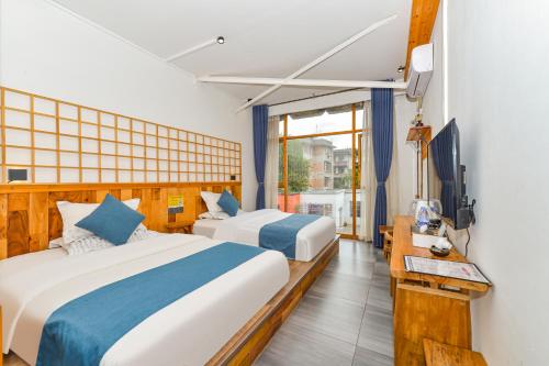 a hotel room with two beds and a television at Guilin Changshe Hotel in Guilin