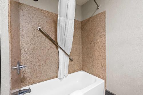 a bathroom with a bath tub with a shower curtain at Days Inn by Wyndham Troy in Troy