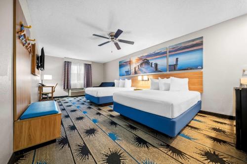 a hotel room with two beds and a ceiling fan at Days Inn by Wyndham Troy in Troy