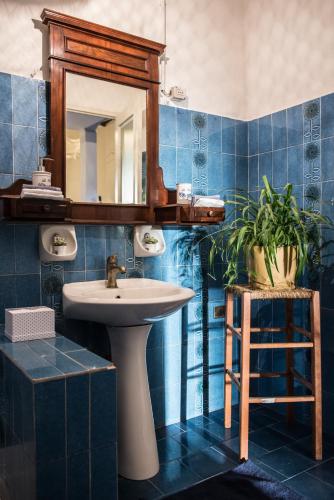 a blue tiled bathroom with a sink and a mirror at Corte dei Brut in Gavirate