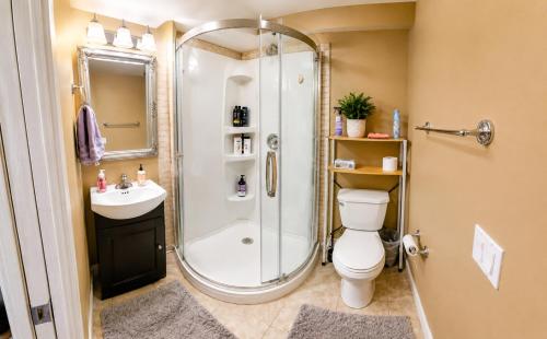 a bathroom with a shower and a toilet and a sink at Tuscan Ridge Guesthouse Calgary West in Calgary