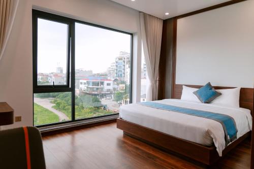 a bedroom with a bed and large windows at Nova Hotel - 诺瓦酒店 in Yên Khê