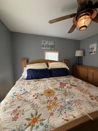 a bedroom with a large bed with a floral bedspread at Rising Sun Rustic Retreat in Roach