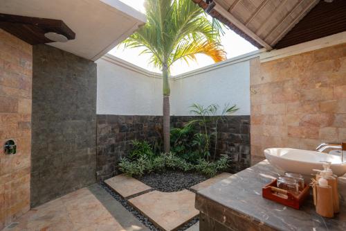 a bathroom with a sink and a palm tree at D'Gume Villas Lembongan in Nusa Lembongan