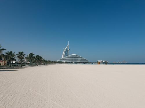 a view of the beach with a building in the background at Full Moon Guesthouse in Dubai