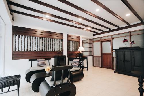 a living room with a couch and chairs and a ceiling at Fullrich Lanna Suite in Chiang Mai
