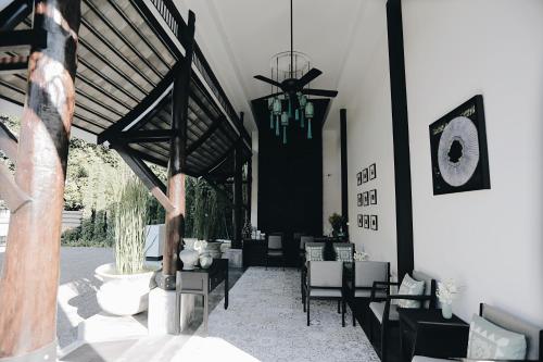 a living room with chairs and a chandelier at Fullrich Lanna Suite in Chiang Mai