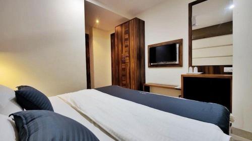 a hotel room with a bed and a television at hotel chandigarh pavilion in Chandīgarh