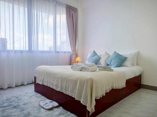 a bedroom with a bed with towels and a window at Xin Hotel at Udomsuk 25 in Bangna