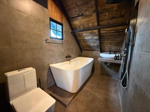 a bathroom with a white tub and a sink at Eden Heaven Villa in Nuwara Eliya