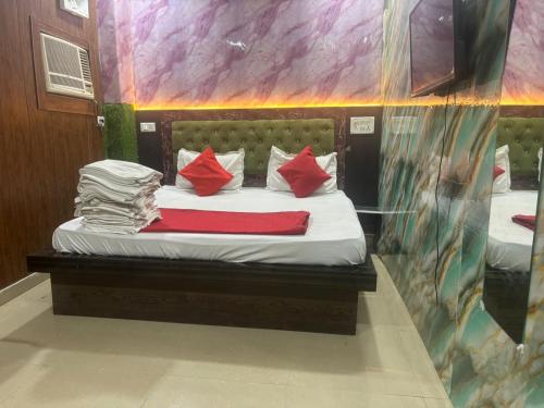 a bed in a room with red pillows on it at Hotel Youvraj Inn in Ghaziabad