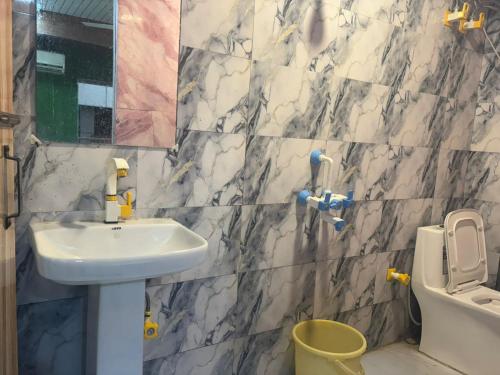 a bathroom with a sink and a toilet at Hotel Youvraj Inn in Ghaziabad