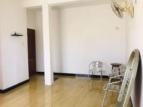 a room with two chairs and a white wall at Bevibe kottawa in Kottawa