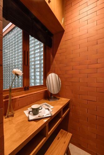 a room with a table with a cup and a lamp at Easterly Room 01 in Chanthaburi