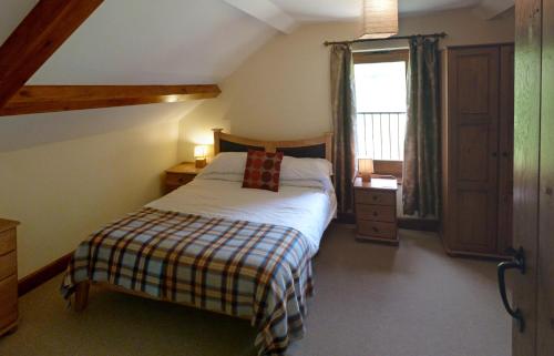a small bedroom with a bed and a window at Beacons View Farm Cottages in Merthyr Cynog
