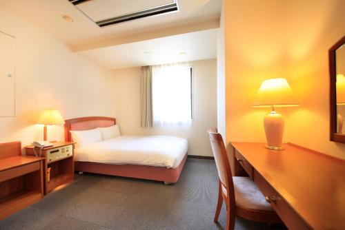 a hotel room with a bed and a desk and a bedroom at Hotel Green Selec in Sendai