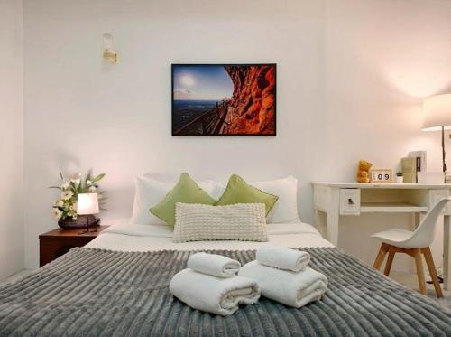 a bedroom with a bed with towels on it at Xin Hotel at Udomsuk 25 in Bangna