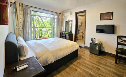 a bedroom with a bed and a large window at Sagarmatha Apartment Hotel in Pātan