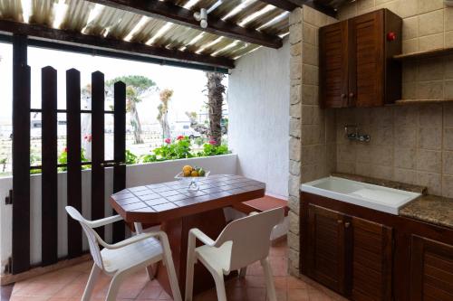 a kitchen with a table and chairs and a sink at Camping Residence Costa Verde in Ricadi